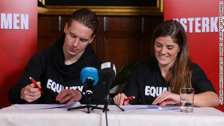Stefan Johansen (L) and Maren Mjelde (R) sign the agreement in London.