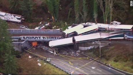 Aerial images show the train sprawled across the track and highway on Monday.