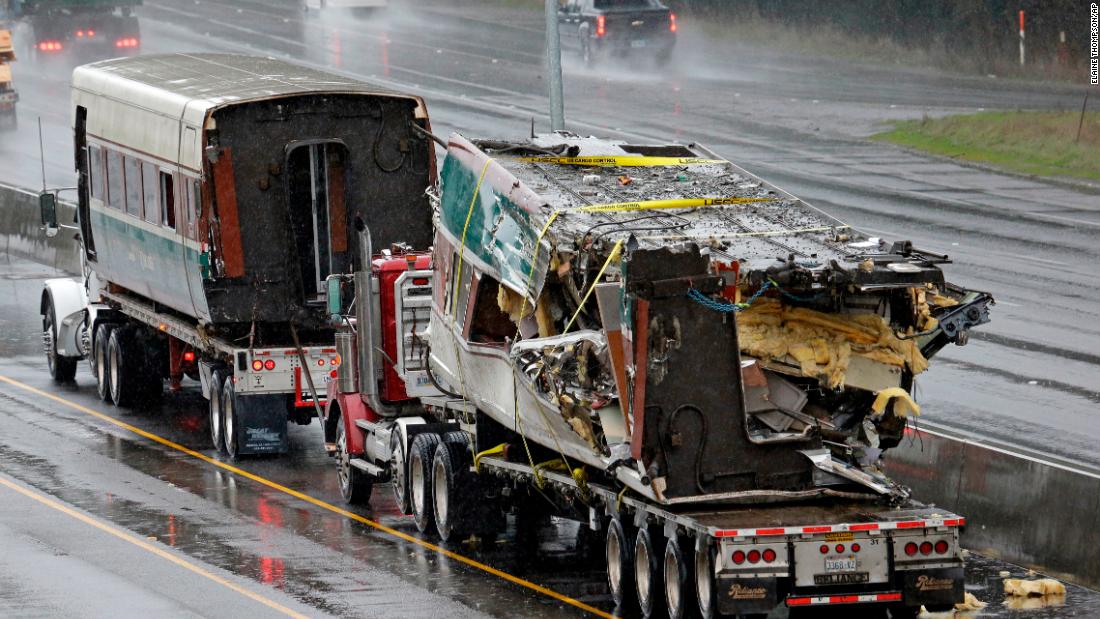 Two damaged train cars sit on flatbed trailers after being taken away from the scene on December 19. When it derailed, the train was going 80 mph in a 30 mph zone. Federal investigators said they don&#39;t know why yet.