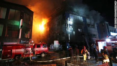 Firefighters work to put out a blaze at an eight-story building in South Korea on Thursday.
