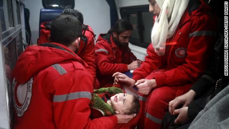 Syrian staff from the International Committee of the Red Cross evacuate a child from Eastern Ghouta on Wednesday. 