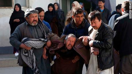 A distraught man is carried away following the suicide attack in Kabul on Thursday.