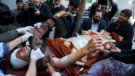 People carry an injured man to hospital after the suicide attack in Kabul on Thursday.