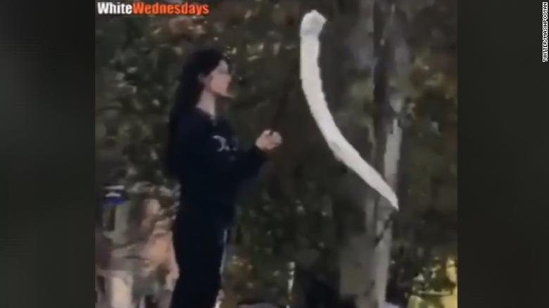 Woman defiantly waves hijab in Iran