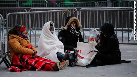 Revellers stay warm in Times Square early Sunday morning as they prepare for New Year&#39;s Eve celebrations.