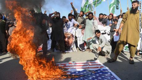 Activists burn the American flag at a protest in Karachi on Tuesday. 