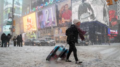 Rebecca Hollis of New Zealand drags her suitcases in a snowstorm through Times Square on her way to a hotel, Thursday, Jan. 4, 2018, in New York. A massive winter storm swept from the Carolinas to Maine on Thursday, dumping snow along the coast and bringing strong winds that will usher in possible record-breaking cold. (AP Photo/Mary Altaffer)