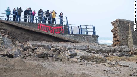 People stop to look at damage to the harbor wall caused by Storm Eleanor in Portreath, Cornwall, in the UK.