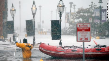 A Boston firefighter wades through floodwaters from Boston Harbor on Thursday, January 4, on Long Wharf in Boston.