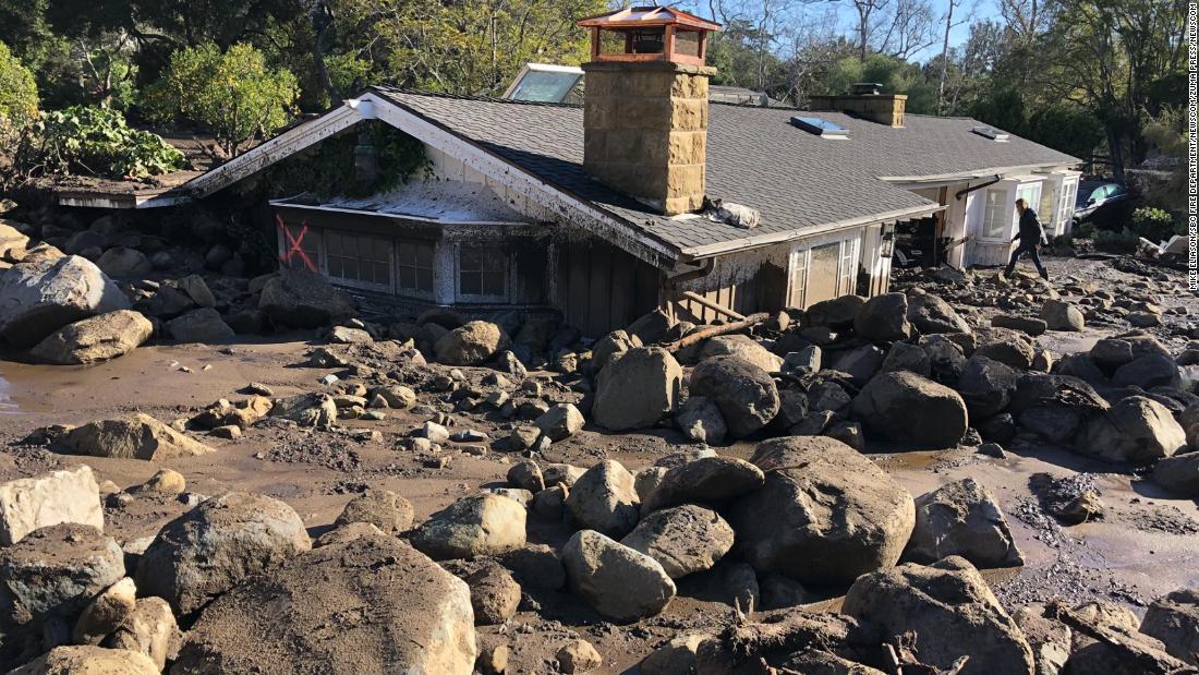 Kerry Mann navigates the large boulders and mudflow that destroyed her friend&#39;s home in Montecito.