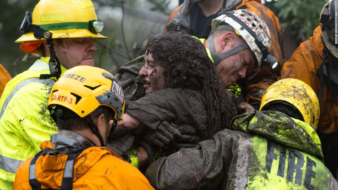 Emergency personnel carry a woman from a collapsed house after a mudslide in Montecito on Tuesday, January 9. 