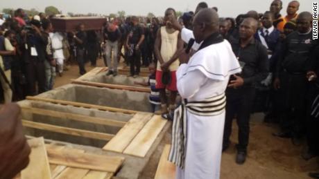 Priest administers burial rites at the mass burial