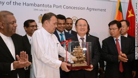 Sri Lanka&#39;s Minister of Ports &amp; Shipping Mahinda Samarasinghe exchanges souvenirs during the Hambantota International Port Concession Agreement at a signing ceremony in Colombo in 2017. 