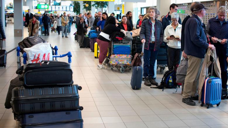 A group of travelers line up at Schiphol Airport near Amsterdam, Thursday.
