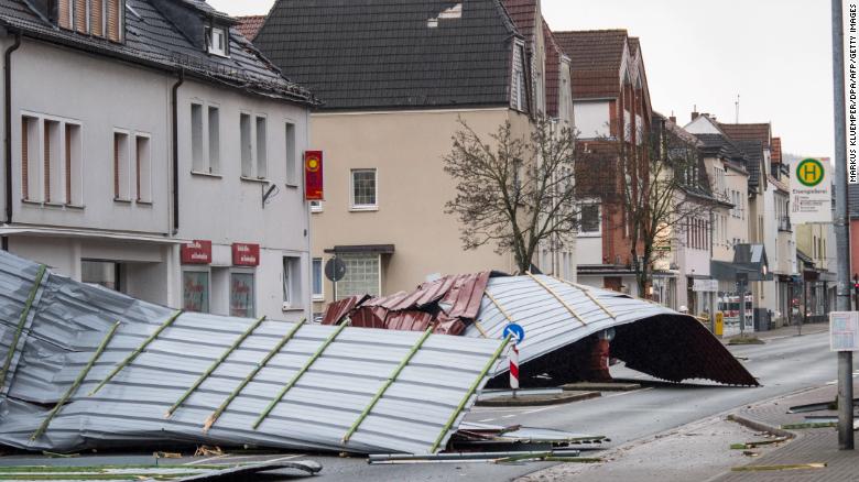 A picture taken on January 18, 2018 shows metal roofing sheets from a supermarket blocking a road in Menden, western Germany, as the region is hit by the storm named &quot;Friederike&quot;.
