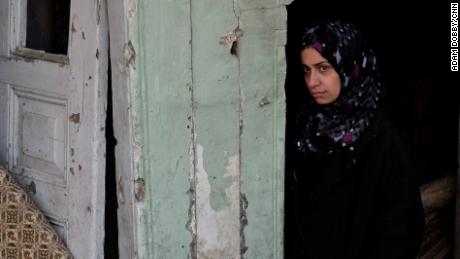 Ashwaq Abu Omran stands in the doorway of her house in the Old City of Mosul. The mother of two says ISIS militants forced the family out of their home and used it as a fighting position. Days later it was levelled in an airstrike. 