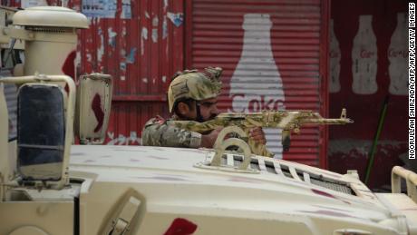 An Afghan army soldier takes a position Wednesday near the Save the Children office in Jalalabad. 