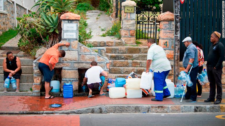 People collect drinking water from pipes fed by an underground spring in St. James, about 25 kilometers from the city center of Cape Town. 