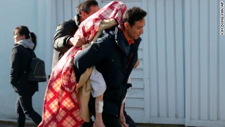 A person injured in the fire is carried to safety in Miryang, South Korea, Friday.
