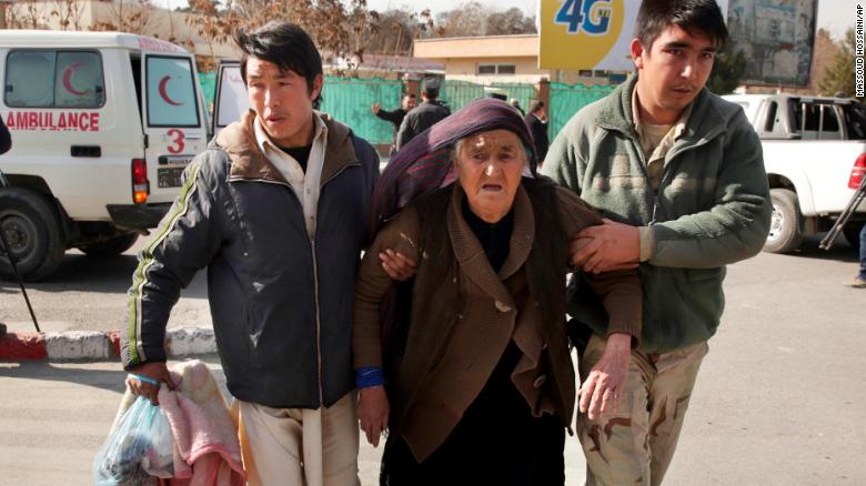 A wounded woman is assisted at the site of the attack Saturday in Kabul.