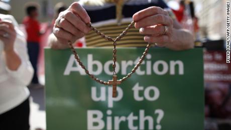 A protester holds rosary beads and an anti-abortion placard in Dublin, Ireland, in July 2013. 