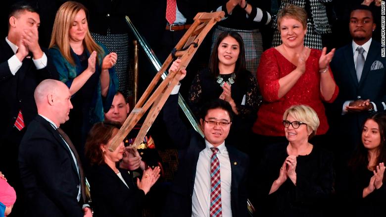 North Korean defector Ji Seong-ho raises his crutches as US President Donald Trump delivers the State of the Union address at the US Capitol in Washington, DC, on January 30, 2018.
 / AFP PHOTO / SAUL LOEB        (Photo credit should read SAUL LOEB/AFP/Getty Images)