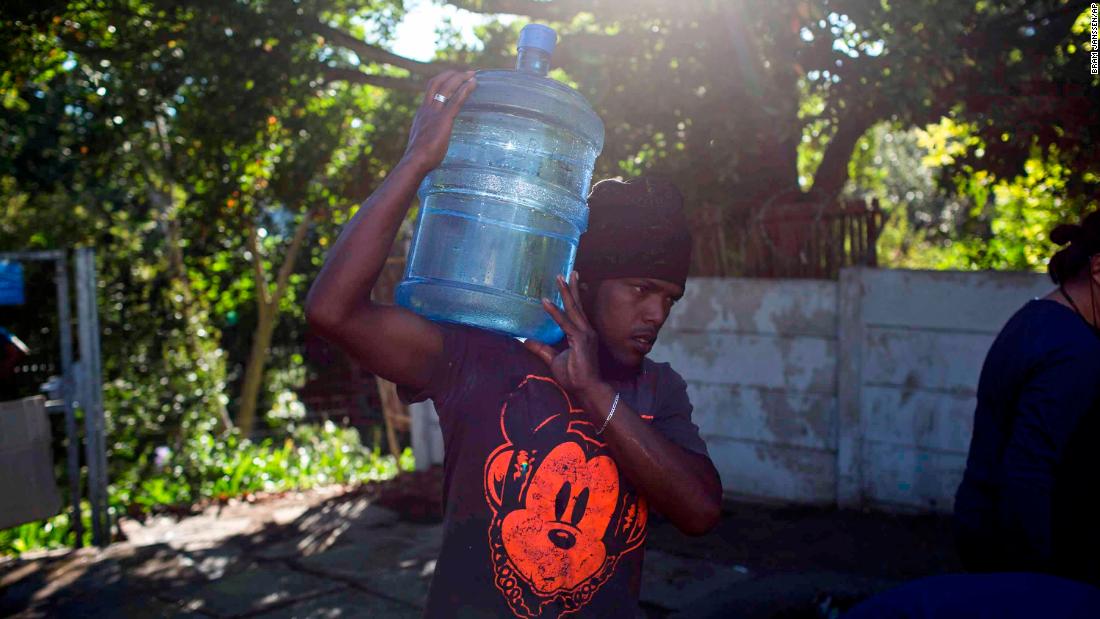 A man in Cape Town, South Africa, carries water from a natural spring on Thursday, February 1.