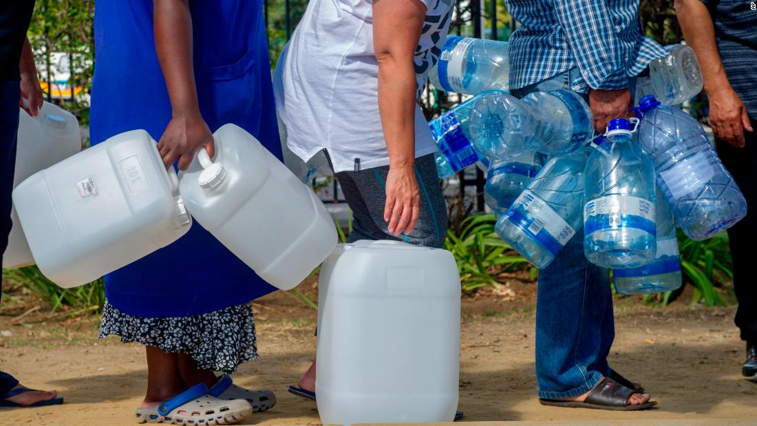 People line up to collect water from a natural spring outlet in Cape Town on Tuesday, January 23.