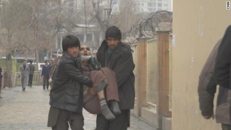 A man is carried into the hospital, as ambulances are no longer allowed to get close following the hospital attack.