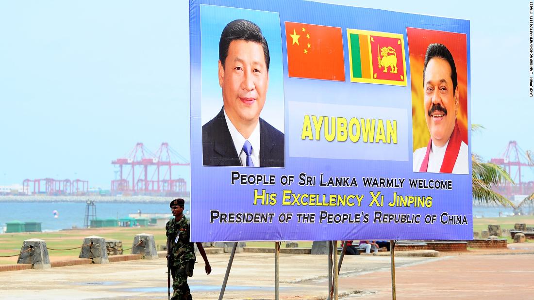 A Sri Lankan soldier walks past a billboard bearing portraits of Chinese President Xi Jinping and Sri Lankan President Mahinda Rajapakse, ahead's of Xi's visit to the Sri Lankan capital Colombo, September 15, 2014. 