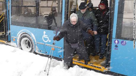 A passenger gingerly leaves a bus during the blizzard in Moscow.