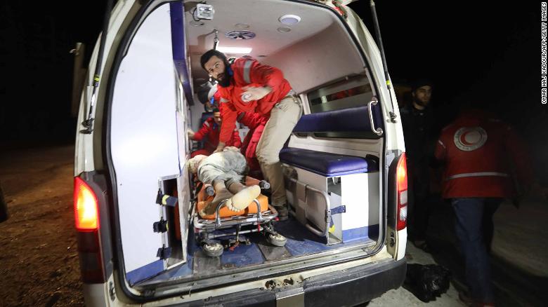 Syrian emergency services treat a victim rescued from a collapsed building after airstrikes on Idlib.