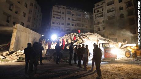 Syrian emergency services search the rubble of a building after government air strikes on Idlib in February. 