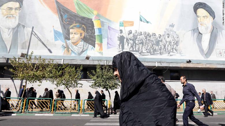 An Iranian woman walks past pictures of Iranian supreme leader Ayatollah Ali Khamenei (top L) and of late Iranian supreme leader Ayatollah Ruhollah Khomeini (top R), following the weekly Friday prayer in Tehran on October 13, 2017.
President Donald Trump will unveil a more aggressive strategy to check Iran&#39;s growing power, but will stop short of withdrawing from a landmark nuclear deal or declaring the powerful Islamic Revolutionary Guard Corps a terrorist organization. During a White House speech at 12:45 pm (1645 GMT), Trump is expected to declare the 2015 agreement -- which curbed Iran&#39;s nuclear program in return for sanctions relief -- is no longer in the US national interest. / AFP PHOTO / STR        (Photo credit should read STR/AFP/Getty Images)