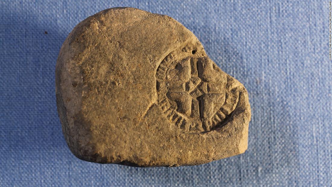 This stone would have been a casting mold for small lead amulets. The cross symbol may show influence from Christian mission.