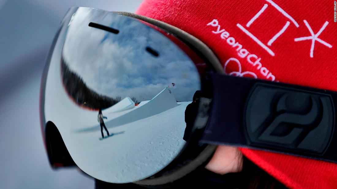 A volunteer watches as athletes run the course during a training session prior to the women&#39;s slopestyle qualifying. 