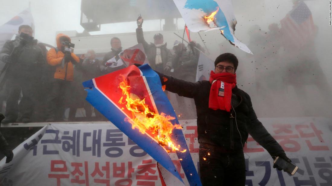 A protester burns a North Korean flag during a rally against North Korea&#39;s participation in the 2018 Pyeongchang Winter Olympics.