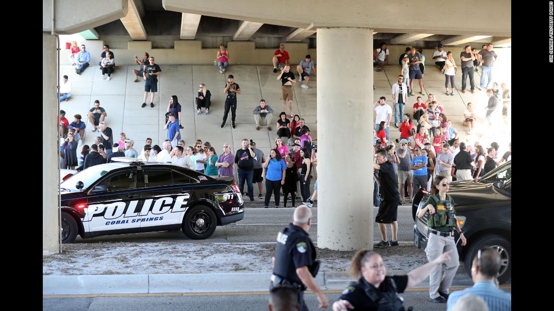 Family members wait for word from students beneath an underpass just south of the campus of Marjory Stoneman Douglas High School.