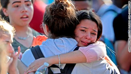 Students released from a lockdown embrace following following a shooting at Marjory Stoneman Douglas High School in Parkland, Fla., Wednesday, Feb. 14, 2018. (John McCall/South Florida Sun-Sentinel via AP)