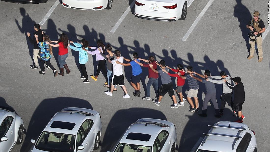 People are brought out of the Marjory Stoneman Douglas High School after the shooting. 