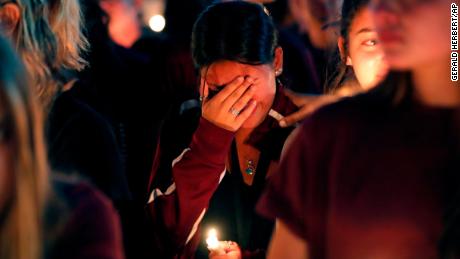 A woman cries during a candlelight vigil for the victims of the Wednesday shooting at Marjory Stoneman Douglas High School, in Parkland, Fla., Thursday, Feb. 15, 2018. Nikolas Cruz, a former student, was charged with 17 counts of premeditated murder on Thursday. (AP Photo/Gerald Herbert)