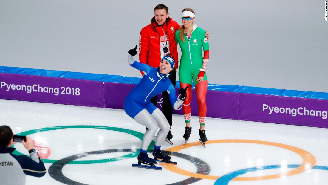 Angelina Golikova, a speedskater from Russia, photobombs teammate Kseniya Sadouskaya and her coach during a practice session.