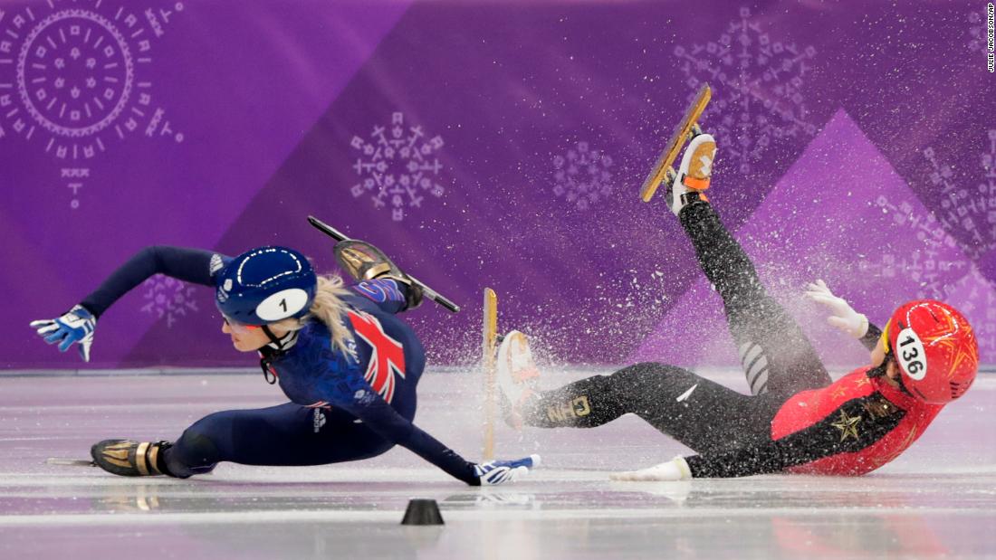 Great Britain&#39;s Elise Christie, left, and China&#39;s Li Jinyu crash during a short-track semifinal for the 1,500 meters. Christie was taken off the ice on a stretcher.