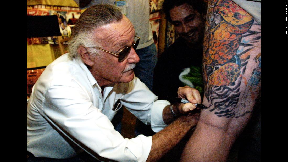 Lee autographs a man&#39;s leg during a book premiere in 2001.