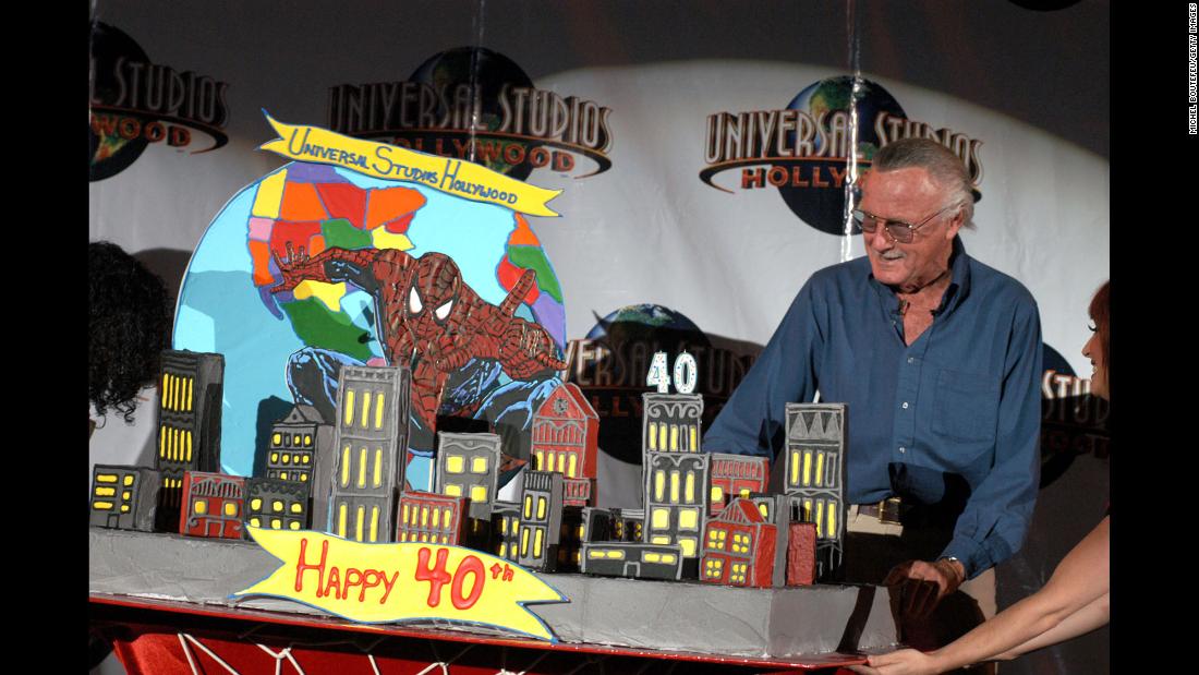 Lee poses by a cake celebrating Spider-Man&#39;s 40th anniversary.