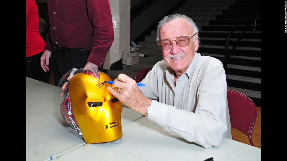 Lee signs an &quot;Iron Man&quot; mask in 2008.