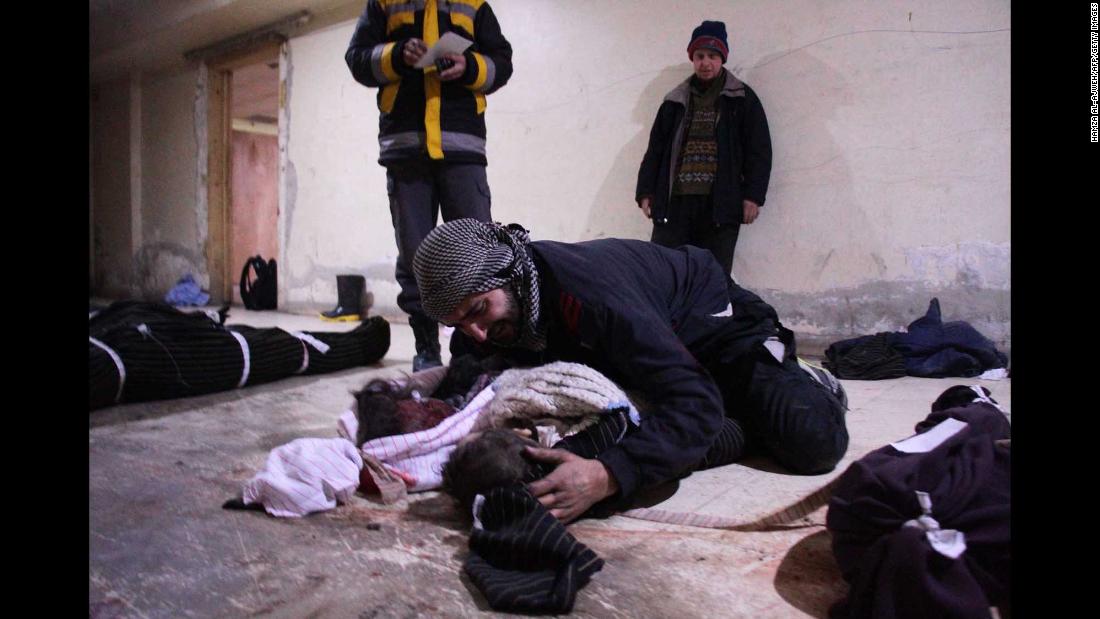 A man weeps over his child, who was killed in the Mesraba airstrikes.