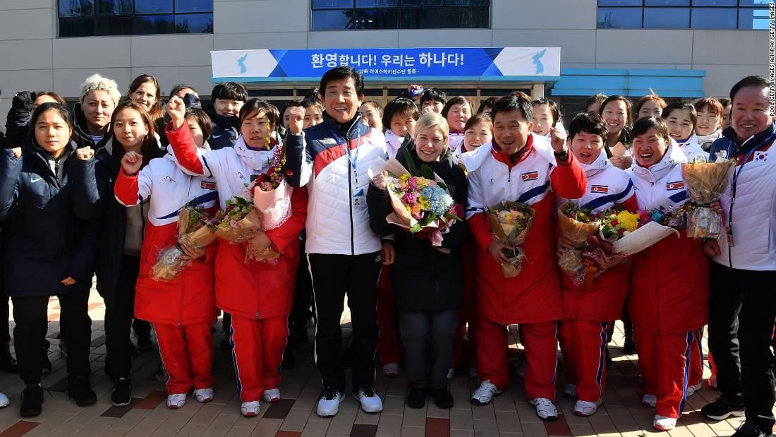 Coaches and players cheer during a welcoming ceremony.