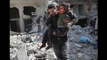 A man rescues a child after a reported regime airstrike in the rebel-held town of Hamouria in Syria&#39;s besieged Eastern Ghouta region on Wednesday, February 21. Some 300 people have died over three days in the bombardment of the rebel enclave, medics and activists say.