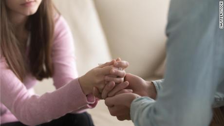 Close up view of upset couple, guy holding hands of crying woman, trying to comfort and console her, boyfriend apologizing offended lady, asking for forgiveness. Support, regret and compassion